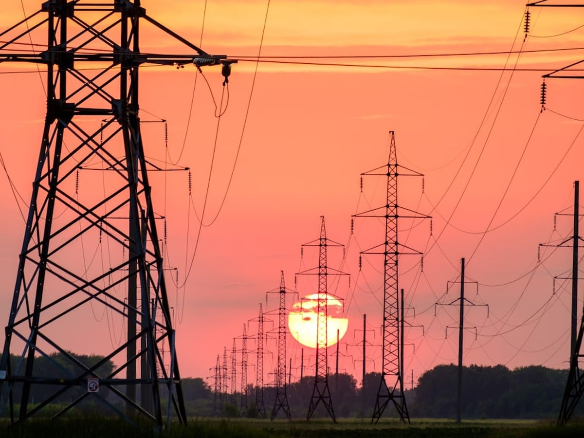 High-voltage transmission and distribution power lines at Texas sunset, representing the TDU wires side of a Texas electric bill