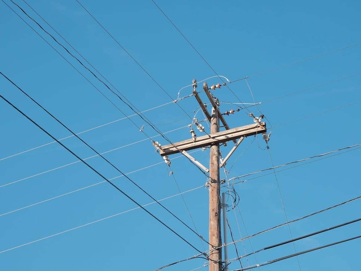 Utility power pole and wires representing the TDU delivery line item on a Texas electricity bill