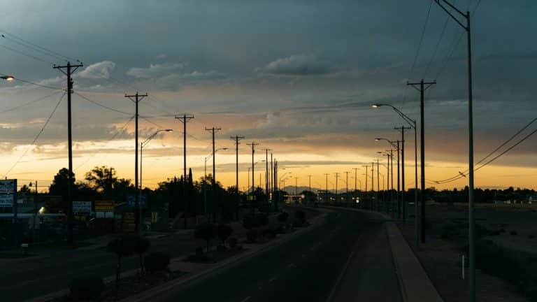 Texas neighborhood street at golden hour with porch lights on, the fall window for renewing an electricity contract