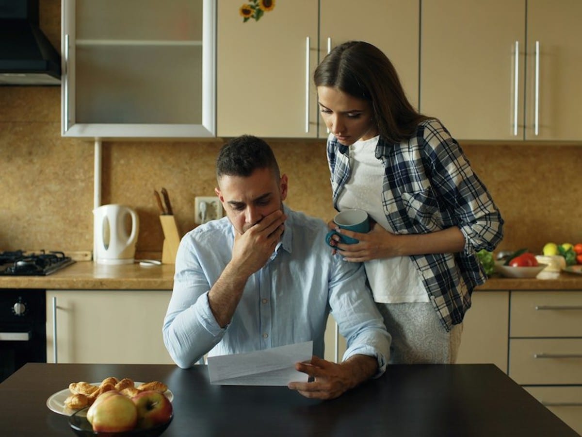 Couple reviewing electricity bills at a kitchen table to compare daytime rates on a free nights plan