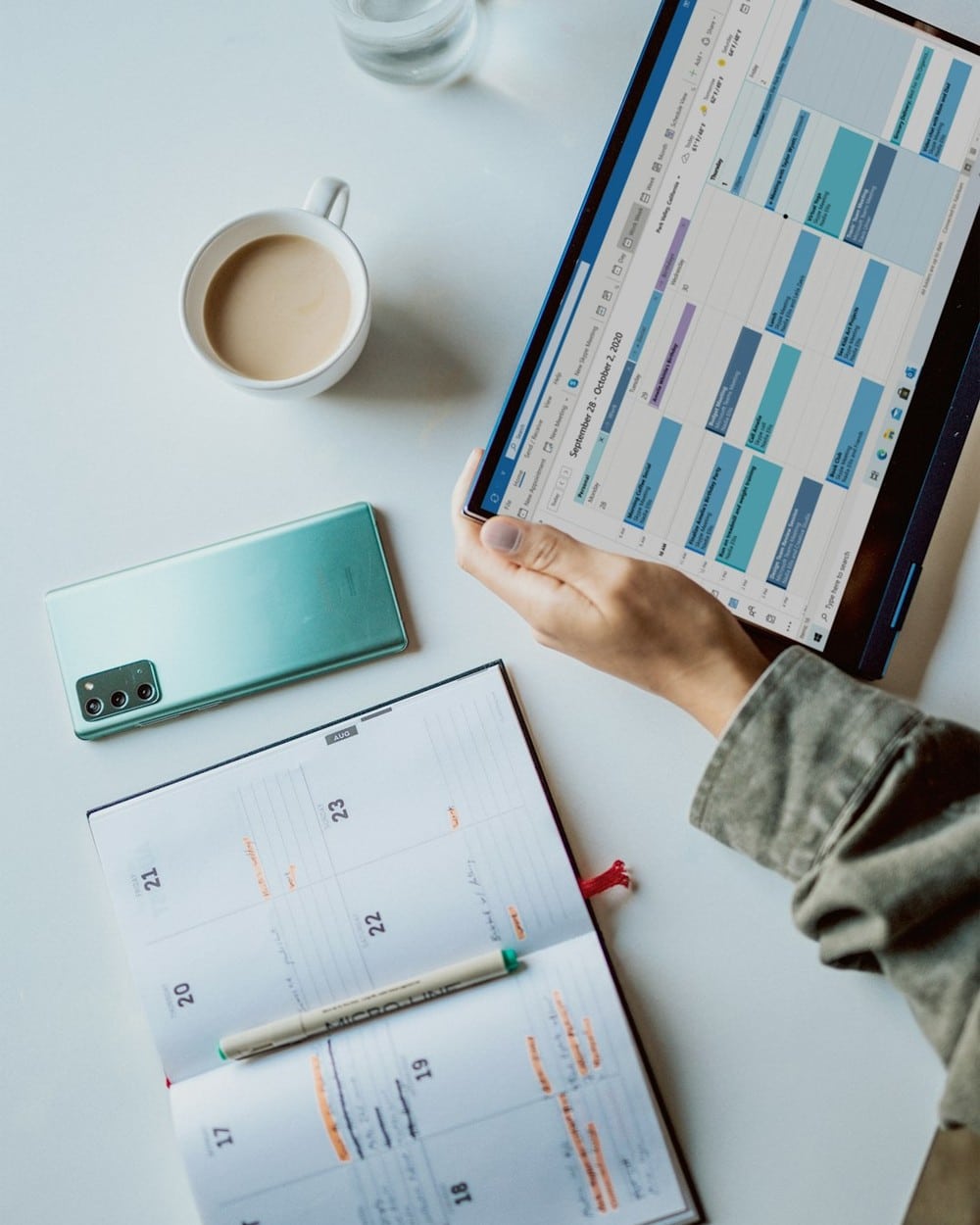 Comparing electricity plans on a tablet beside a laptop and coffee mug