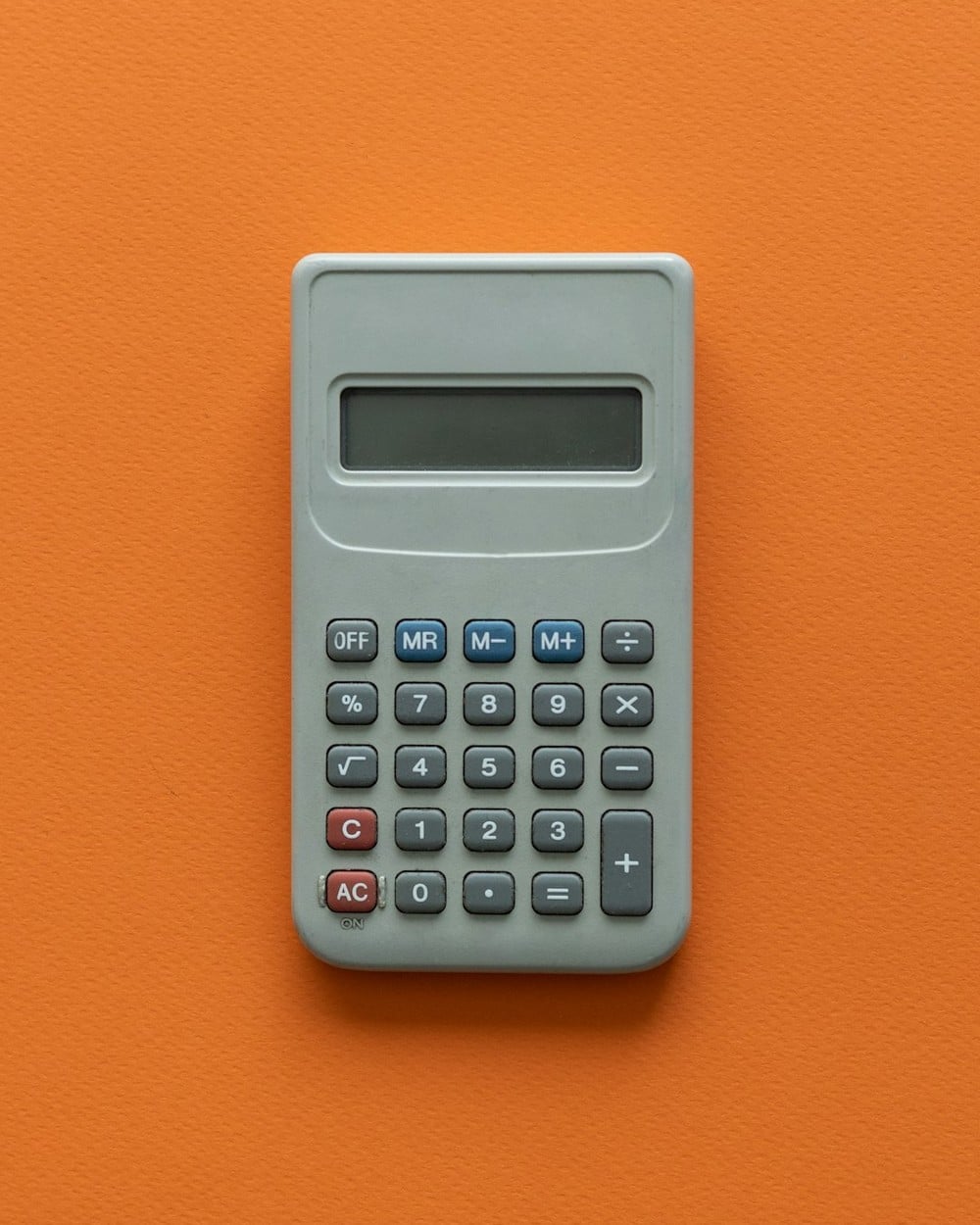Calculator on a table for checking the delivery charge math on an electric bill